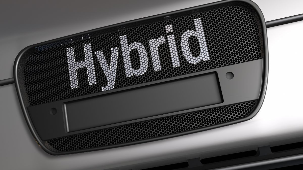 Detail hybridného auta s nápisom 'Hybrid' na mriežke chladiča.