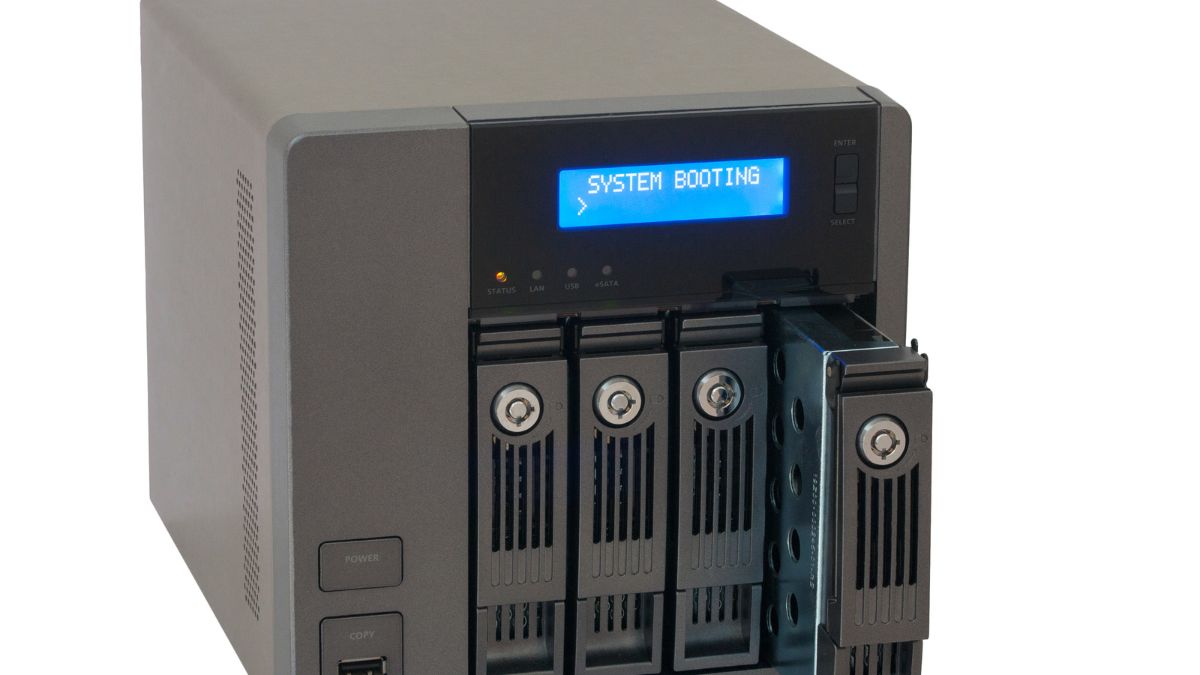 NAS server s viacerými diskovými pozíciami a modrým displejom, ktorý zobrazuje bootovací proces.