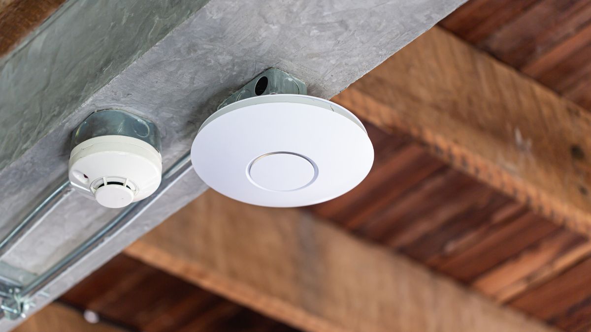 Biely access point pripevnený na strope, zlepšujúci Wi-Fi signál.