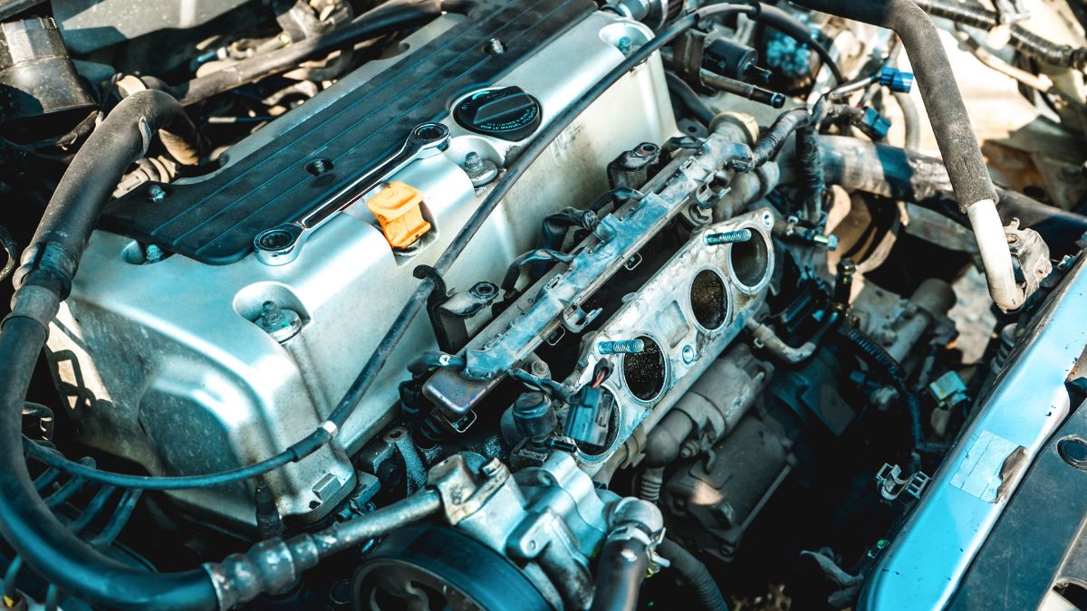 Detailný pohľad na spaľovací motor s viditeľnými súčiastkami a hadicami.