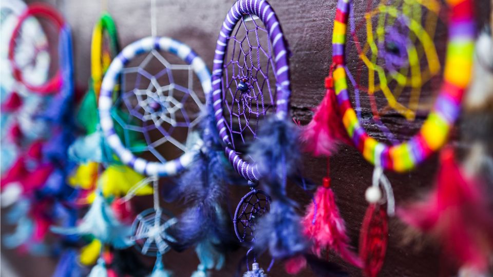 Farebné lapače snov visia na stene, symbolizujúce duchovné posolstvá.