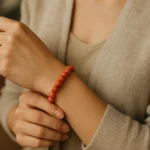 Korálový náramok na ruke s jemným dizajnom