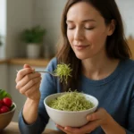 Žena vychutnáva reďkovkové klíčky z misky s úsmevom.