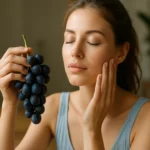 Žena drží modré hrozno, stará sa o svoju pleť.