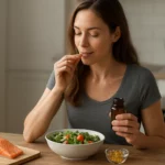 Žena vychutnávajúca si šalát a omega-3 doplnky pri zdravom jedle.