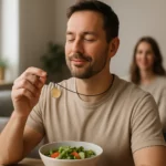 Muž s prémiovým medailónom a šalátom na jedálenskom stole