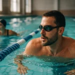 Muž pláva v bazéne, podporuje zdravie a kondíciu.