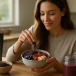 Žena posypáva acai prášok na smoothie misku plnú ovocia