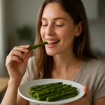Žena si vychutnáva čerstvú špargľu na tanieri.