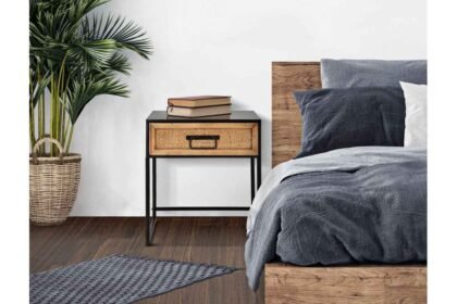 Dizajnový nočný stolík vedľa postele so zelenou rastlinou