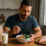 Muž vychutnávajúci si zdravé jedlo s bielkovinami v kuchyni.