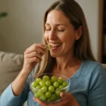 Žena si vychutnáva čerstvé hrozno v obývacej izbe