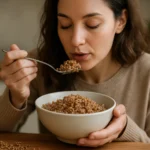 Žena vychutnáva si pohánkovú kašu z misky na zdravé raňajky.