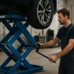 Mechanik používajúci nožnicový zdvihák na zdvíhanie vozidla