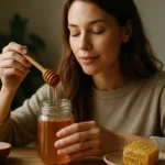 Žena s medom a lyžičkou, užívajúca si výhody medu pre zdravie.