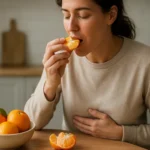 Žena si vychutnáva mandarínku, zdravý dezert podporujúci trávenie.