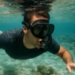 Muž šnorchluje pod vodou a objavuje morský svet.