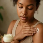 Žena nanáša bambucké maslo na pleť pre hydratačné účinky.