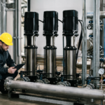 Technik kontroluje viacstupňové čerpadlo v priemyselnom prostredí.