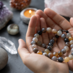 Achátové perly v rukách so vzácnymi nerastmi na pozadí