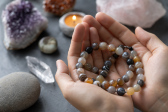 Achátové perly v rukách so vzácnymi nerastmi na pozadí