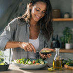 Žena pripravuje zdravý šalát s avokádom a olivovým olejom.