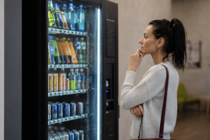 Žena premýšľa nad výberom nápoja z nápojového automatu