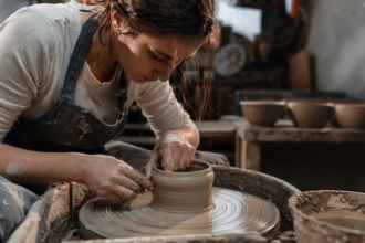 Umelkyňa tvaruje hlinu na hrnčiarskom kruhu