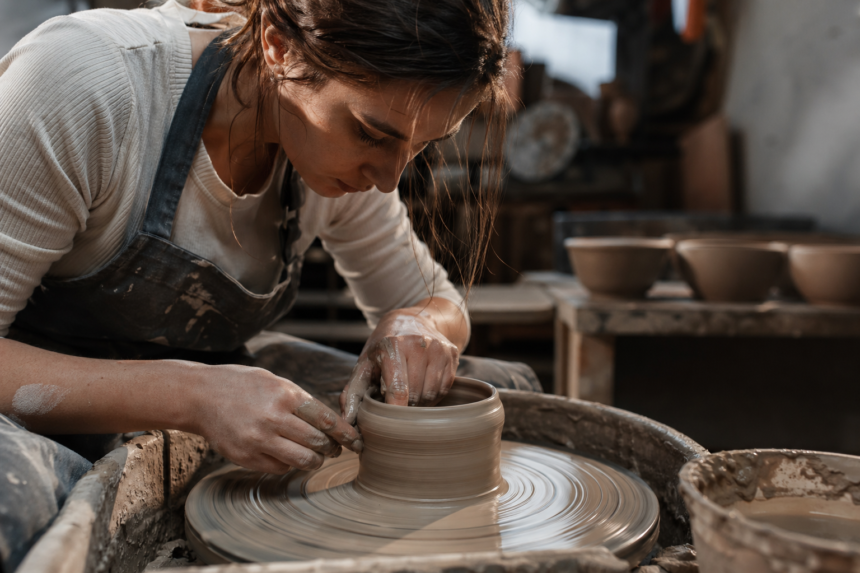 Umelkyňa tvaruje hlinu na hrnčiarskom kruhu
