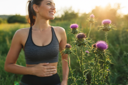 Žena s bruchom pri ostropestreci mariánskom v prírode