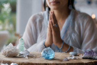 Osoba s modrým topázom a kryštálmi počas meditácie.