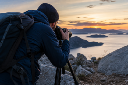 Fotograf so statívom zachytáva nádherný západ slnka