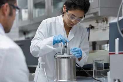 Žena v laboratóriu ovláda kalorimeter na meranie tepla.