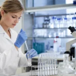 Žena v laboratóriu pracuje s testovacími skúmavkami a pipetou.